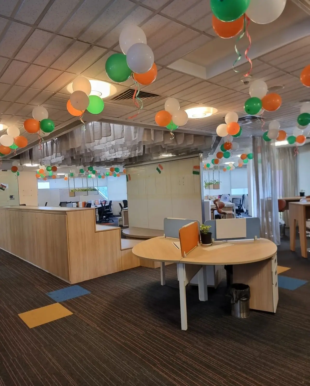 Orange, white and green balloon ceiling decoration in a corporate office